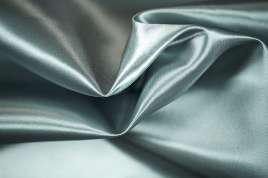 Satinstoff in gedecktem Blau mit fließendem Fall