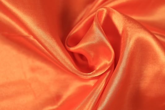 Leuchtend orangener Satinstoff mit glänzender Textur
