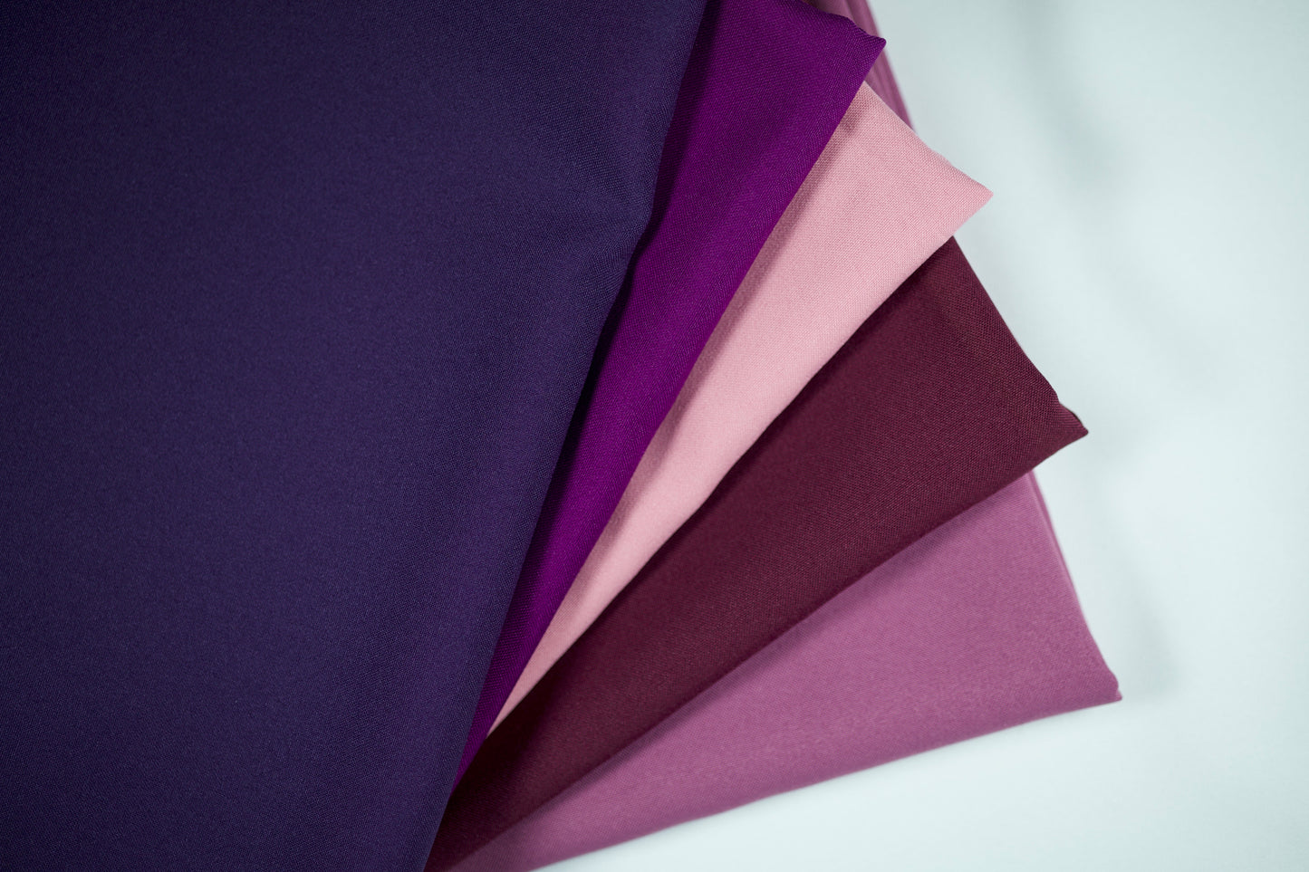 Polyester Panama Stoffe in Violett-Tönen – Farbverlauf von Dunkelviolett über Violett und Altrosa bis Flieder, nebeneinandergelegt für eine harmonische Farbübersicht