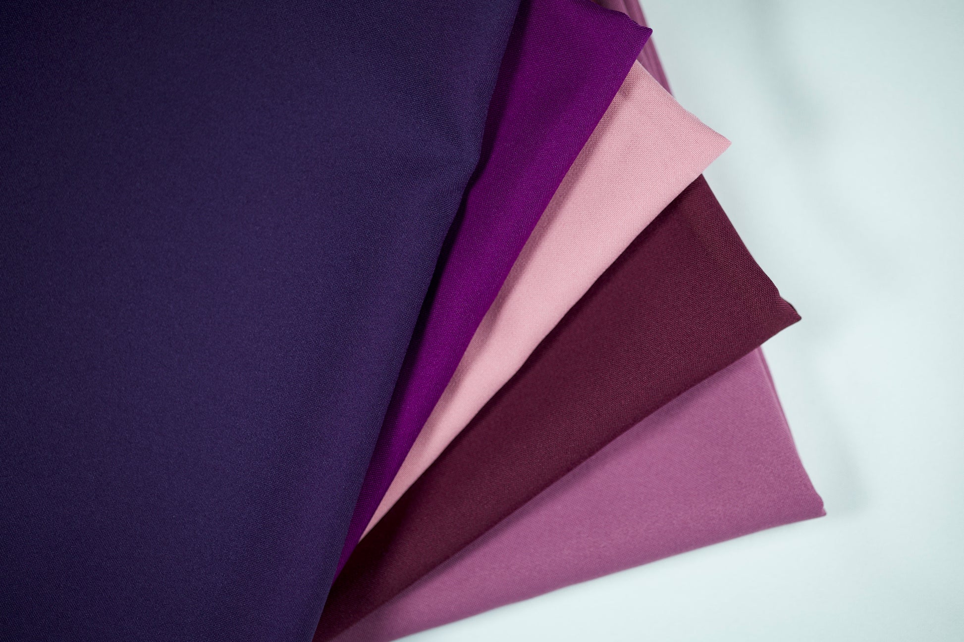Polyester Panama Stoffe in Violett-Tönen – Farbverlauf von Dunkelviolett über Violett und Altrosa bis Flieder, nebeneinandergelegt für eine harmonische Farbübersicht
