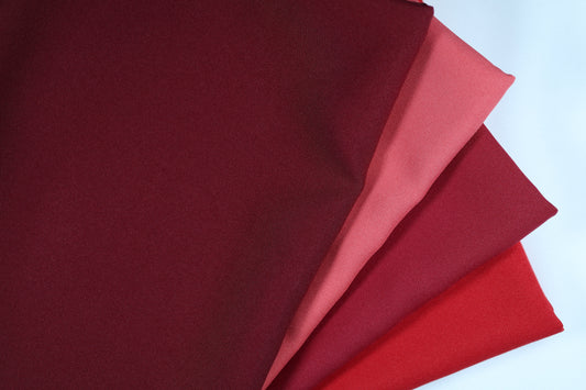 Polyester Panama Stoffe in Weinrot- und Rot-Tönen – nebeneinandergelegt von Weinrot über Rot bis hin zu strukturiertem Rot für elegante Farbvergleiche bei Dekostoffen